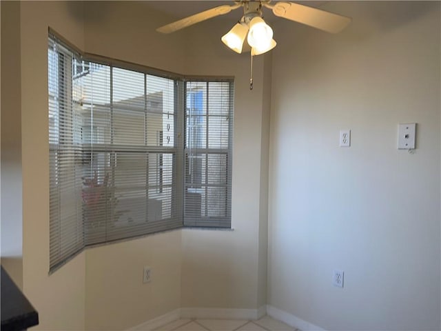 tiled empty room featuring ceiling fan