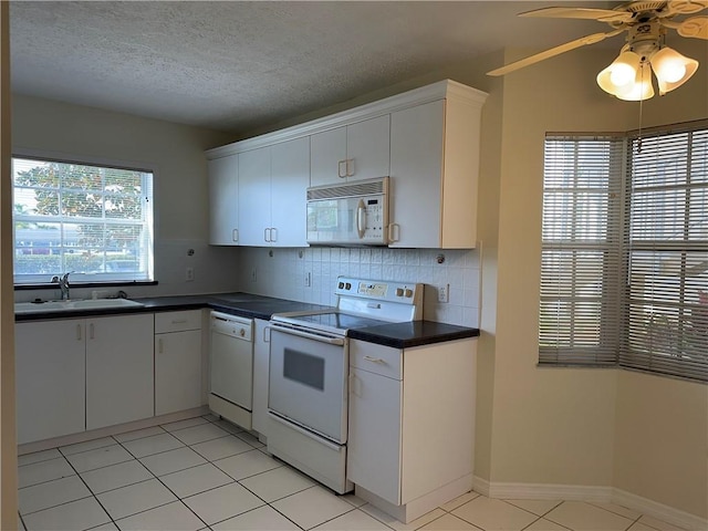 kitchen featuring tasteful backsplash, white cabinetry, sink, and white appliances