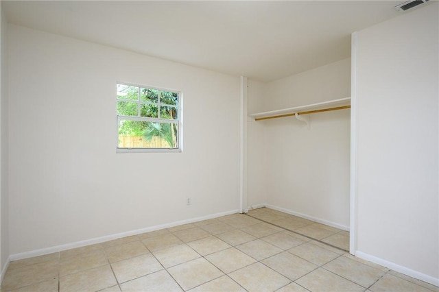 2313 2nd St SW, Vero Beach, FL 32962 - unfurnished bedroom featuring a closet, light tile patterned floors, and baseboards