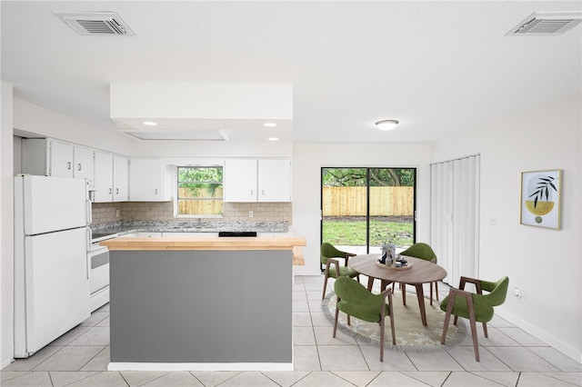 2313 2nd St SW, Vero Beach, FL 32962 - kitchen featuring white appliances, wood counters, decorative backsplash, light tile patterned floors, and recessed lighting