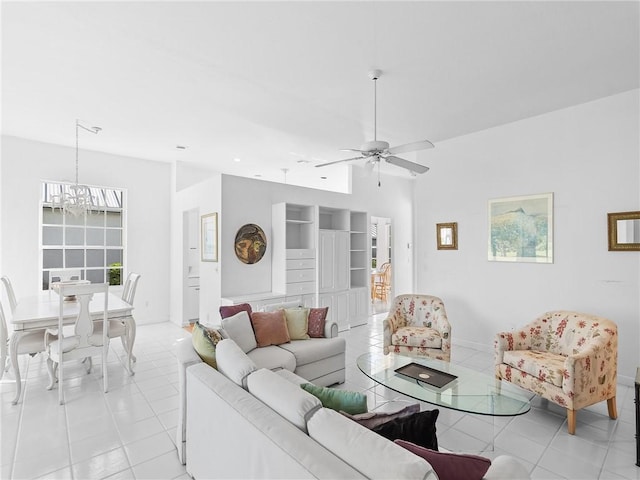 tiled living room with ceiling fan with notable chandelier