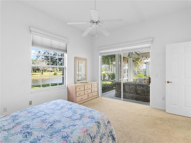 carpeted bedroom with ceiling fan, a water view, and access to outside