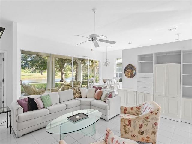 living room featuring ceiling fan with notable chandelier and light tile patterned floors