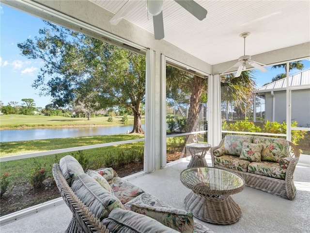 sunroom with ceiling fan and a water view