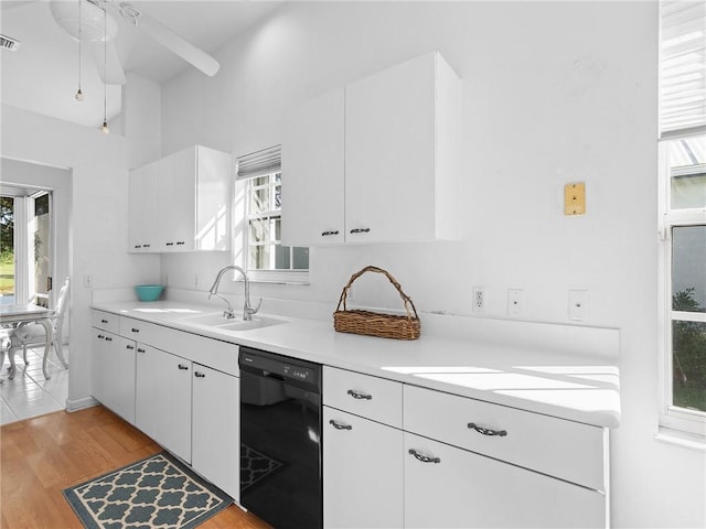 kitchen with white cabinetry, ceiling fan, sink, black dishwasher, and light hardwood / wood-style flooring