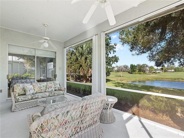 sunroom / solarium featuring ceiling fan and a water view