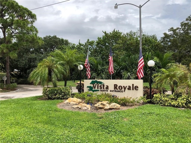 community / neighborhood sign with a yard