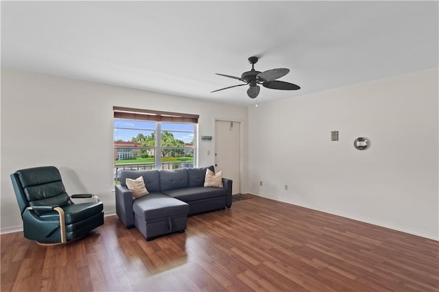 living room featuring ceiling fan and dark hardwood / wood-style flooring