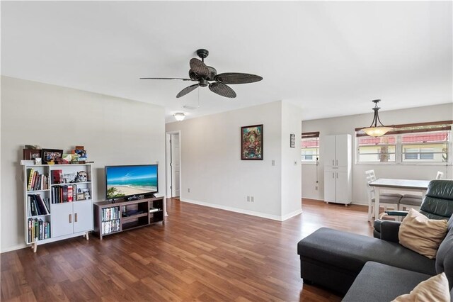 living room featuring dark wood-type flooring and ceiling fan