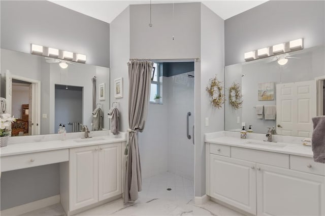 ensuite bathroom with a ceiling fan, marble finish floors, a shower stall, two vanities, and a high ceiling