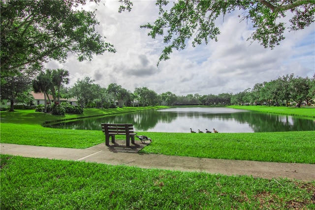 surrounding community featuring a water view and a lawn