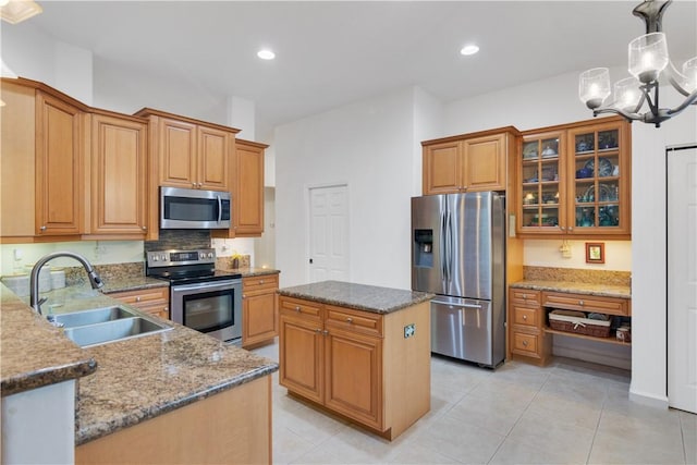 kitchen featuring appliances with stainless steel finishes, a sink, stone counters, glass insert cabinets, and recessed lighting