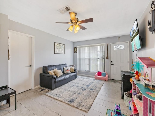 living room featuring ceiling fan and visible vents