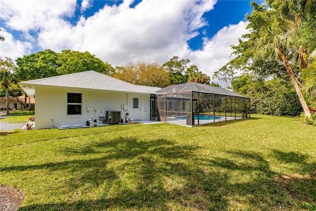 back of house with a yard, glass enclosure, an outdoor pool, and stucco siding