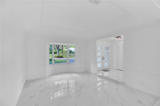 spare room featuring a tray ceiling, marble finish floor, visible vents, and french doors