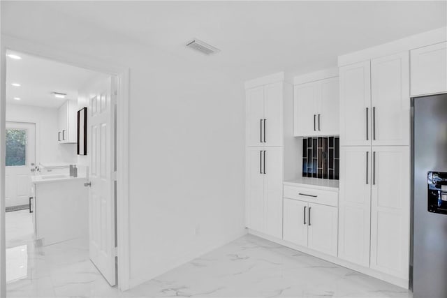 hall with recessed lighting, marble finish floor, and visible vents