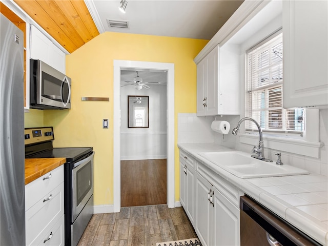 kitchen with white cabinets, appliances with stainless steel finishes, a wealth of natural light, and sink