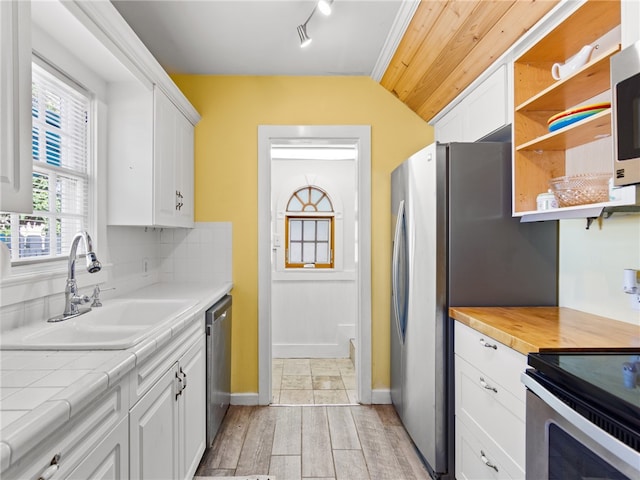 kitchen featuring stainless steel dishwasher, white cabinetry, sink, and light hardwood / wood-style flooring