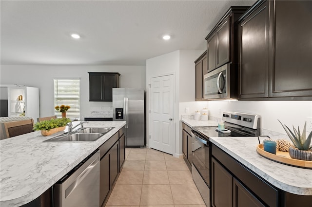 1093 Wabash Rd SE, Palm Bay, FL 32909 - kitchen with stainless steel appliances, a sink, light countertops, light tile patterned floors, and open floor plan