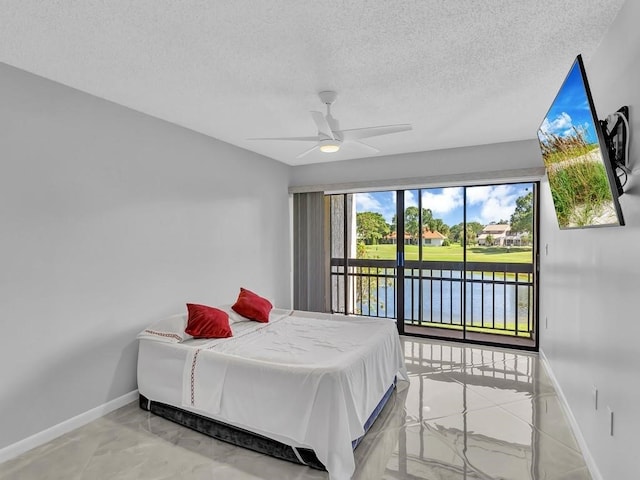 bedroom featuring access to exterior, a textured ceiling, and ceiling fan