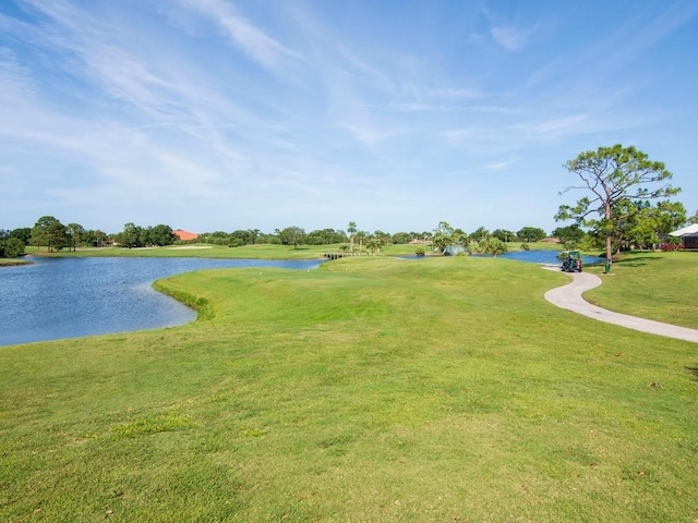 view of home's community with a water view and a yard