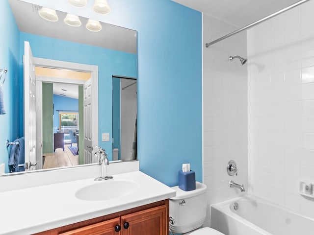 full bathroom featuring vanity, tiled shower / bath combo, and toilet