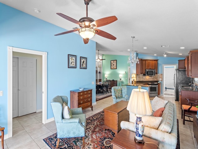 tiled living room with sink and ceiling fan with notable chandelier