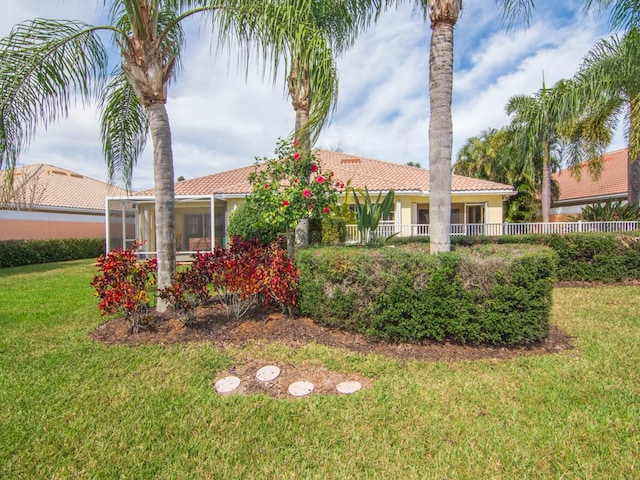 view of front of house with a sunroom and a front lawn