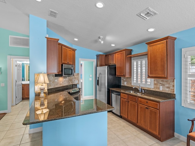 kitchen featuring a textured ceiling, stainless steel appliances, and a healthy amount of sunlight