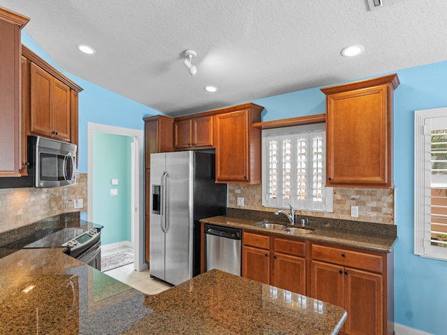 kitchen featuring a textured ceiling, appliances with stainless steel finishes, sink, and light tile patterned flooring