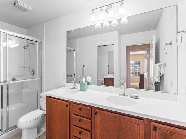 bathroom with walk in shower, vanity, and toilet