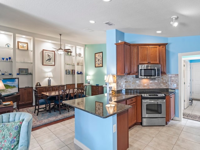 kitchen featuring light tile patterned flooring, appliances with stainless steel finishes, a textured ceiling, kitchen peninsula, and ceiling fan