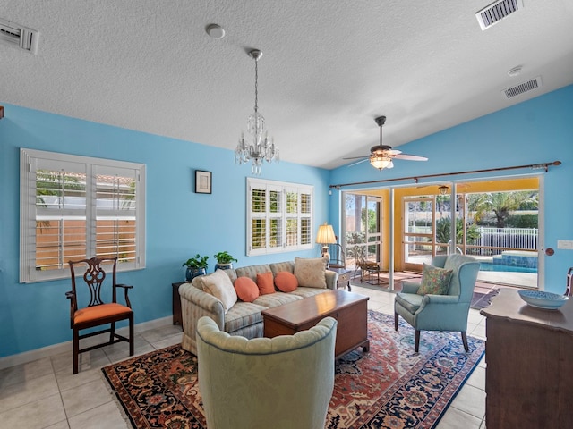 living room with light tile patterned flooring, ceiling fan with notable chandelier, plenty of natural light, and lofted ceiling