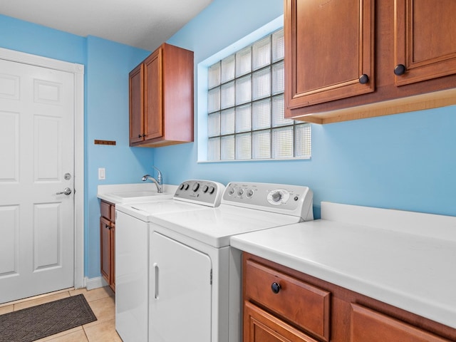 washroom featuring cabinets, sink, light tile patterned floors, and separate washer and dryer