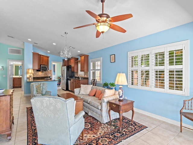 living room featuring light tile patterned flooring, a textured ceiling, sink, vaulted ceiling, and ceiling fan with notable chandelier