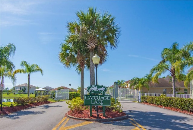 1440 Carriage Ct, Vero Beach, FL 32966 - view of asphalt street featuring a gate, street lights, and traffic signs