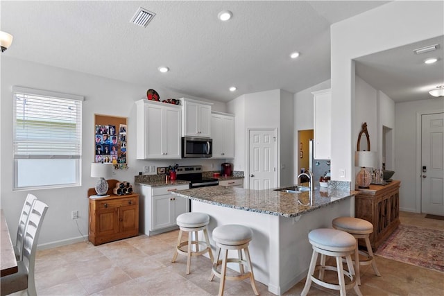 1440 Carriage Ct, Vero Beach, FL 32966 - kitchen featuring stainless steel appliances, a sink, a breakfast bar, stone counters, and recessed lighting