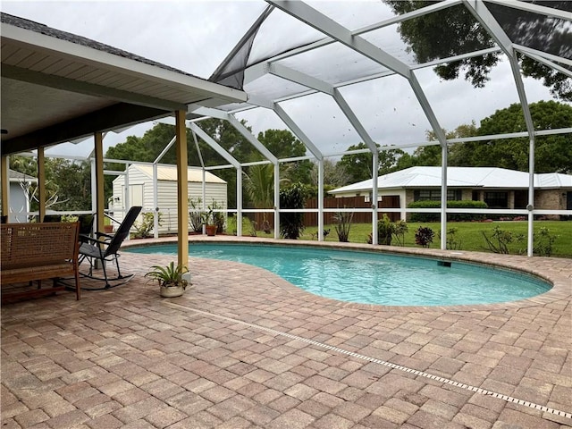 pool with an outbuilding, a patio area, a lanai, and a storage shed