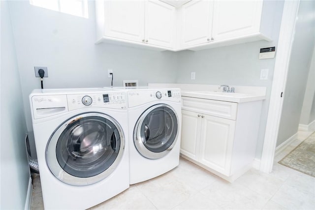 laundry room featuring cabinets, light tile patterned floors, sink, and washing machine and clothes dryer