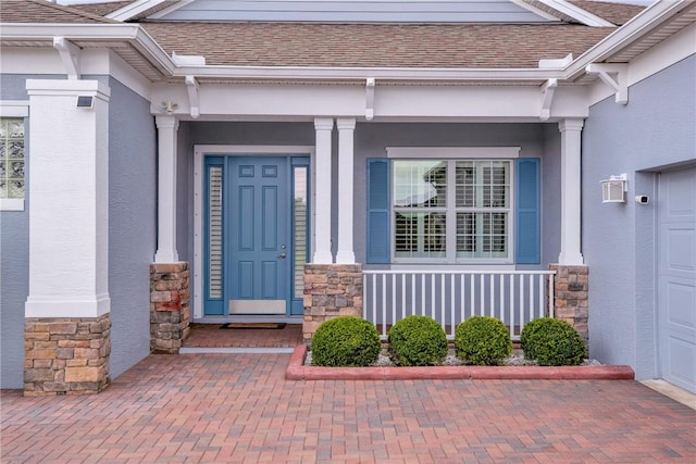 doorway to property with stone siding, roof with shingles, and stucco siding