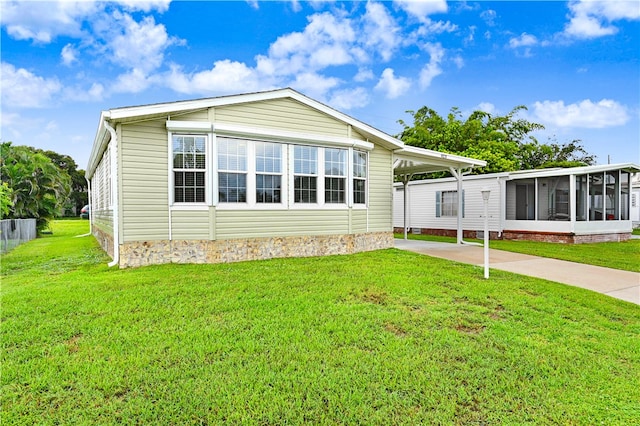 rear view of property featuring a patio, a sunroom, and a yard