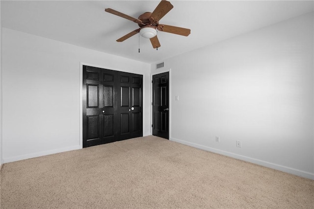 unfurnished bedroom featuring carpet floors, a closet, and ceiling fan