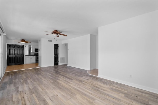 unfurnished living room featuring light hardwood / wood-style flooring and ceiling fan