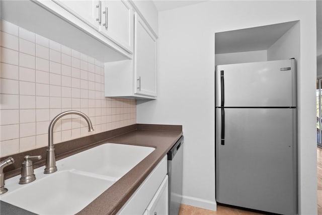 kitchen with backsplash, sink, white cabinets, and stainless steel appliances