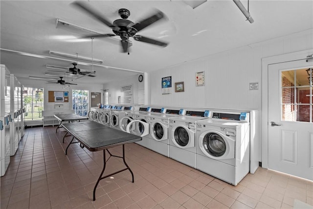 washroom featuring wooden walls, ceiling fan, light tile patterned floors, stacked washer / dryer, and washing machine and clothes dryer