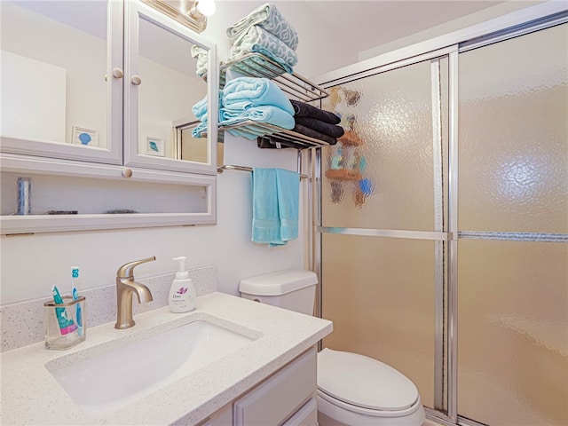 bathroom with toilet, an enclosed shower, and vanity