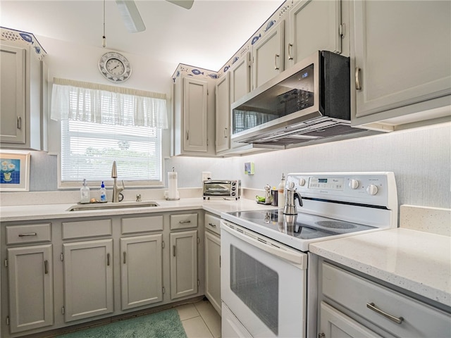 kitchen featuring gray cabinetry, electric range, sink, ceiling fan, and light tile patterned flooring