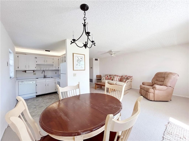 dining space featuring a textured ceiling, ceiling fan with notable chandelier, and baseboards