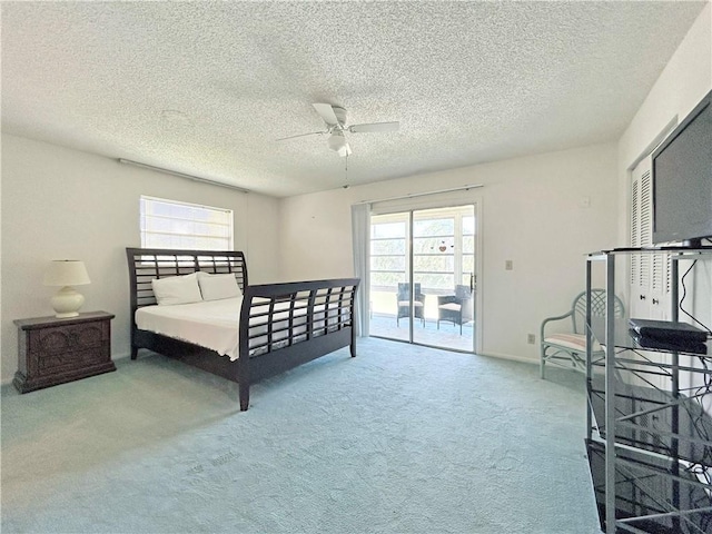 carpeted bedroom featuring access to exterior, ceiling fan, baseboards, and a textured ceiling