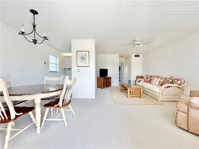 dining room featuring visible vents, a textured ceiling, and ceiling fan with notable chandelier